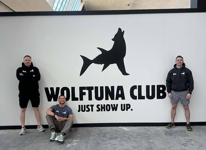 Wolftuna Club members at the Wolftuna Club sign