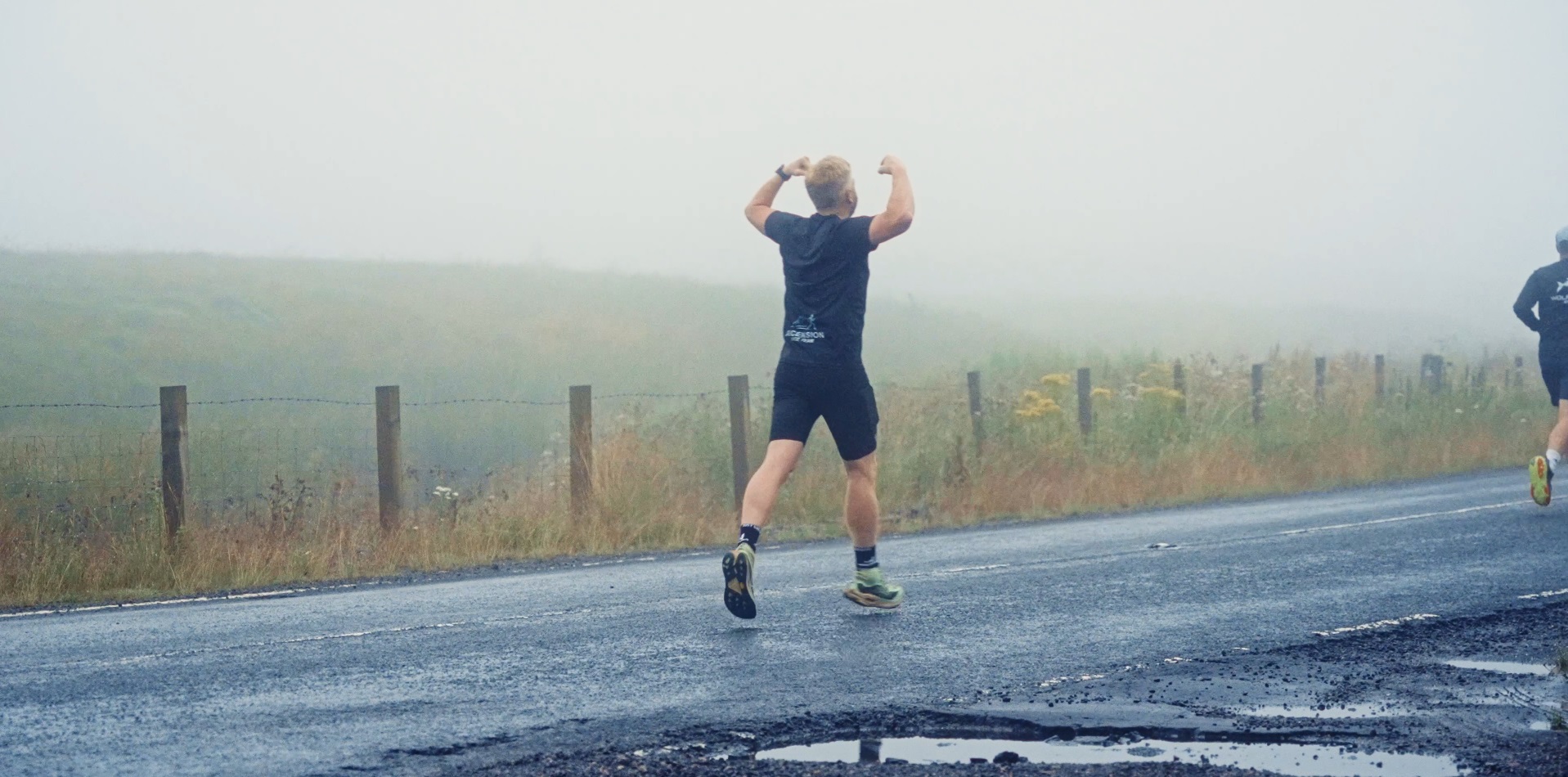 A Wolftuna runner celebrating on a misty Campsies road