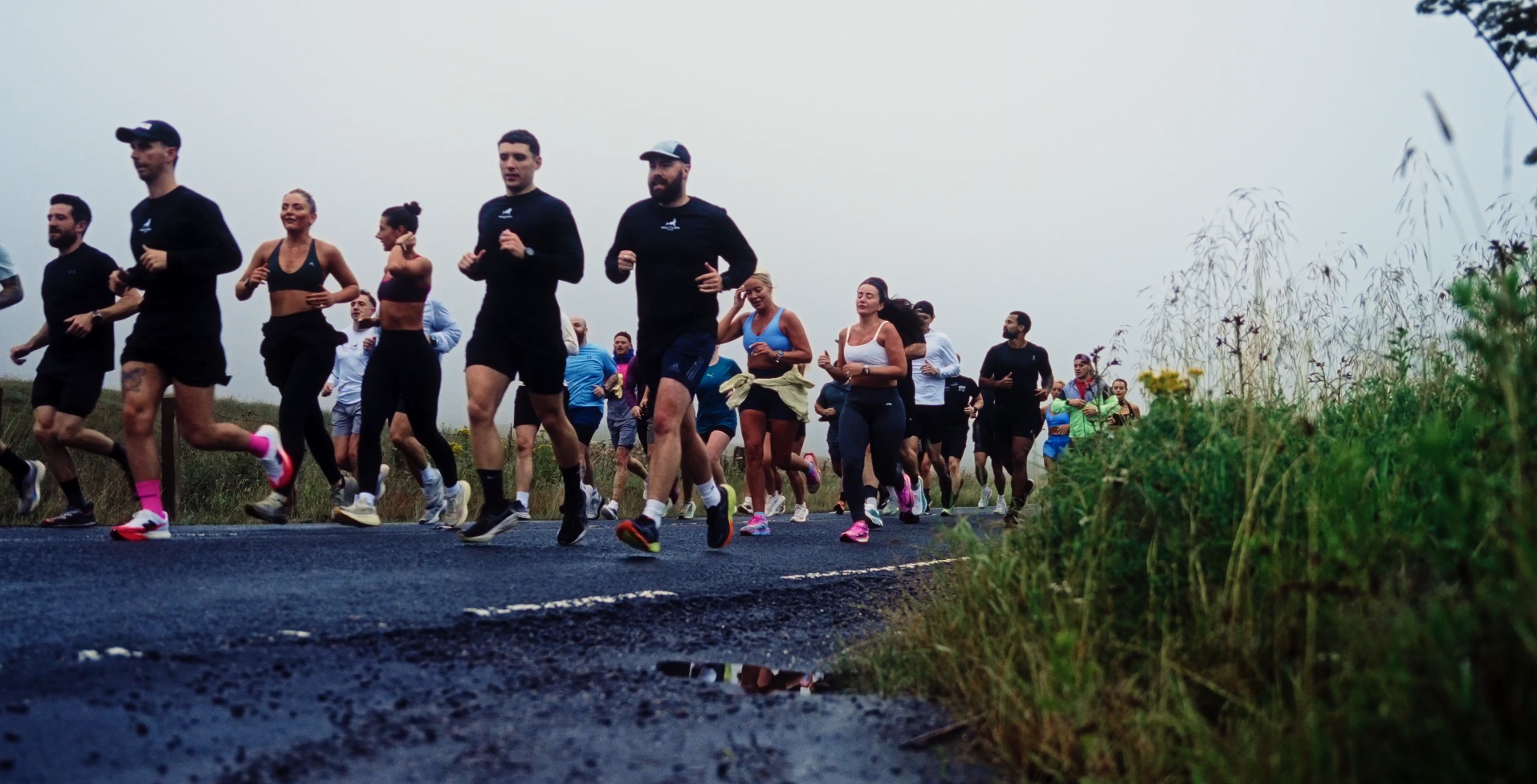 A large group of Wolftuna runners on a misty Campsies road
