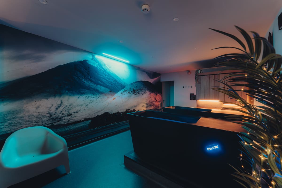 Cold plunge tub in front of the mountain mural at the Wolftuna Wellness Lounge